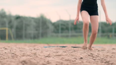 Junge-Sportlerin-Springt-In-Den-Sand-Und-Rettet-Einen-Punkt-Während-Eines-Beachvolleyballspiels.-Fröhliches-Kaukasisches-Mädchen-Springt-Und-Kracht-Während-Eines-Beachvolleyballturniers-In-Den-Weißen-Sand.